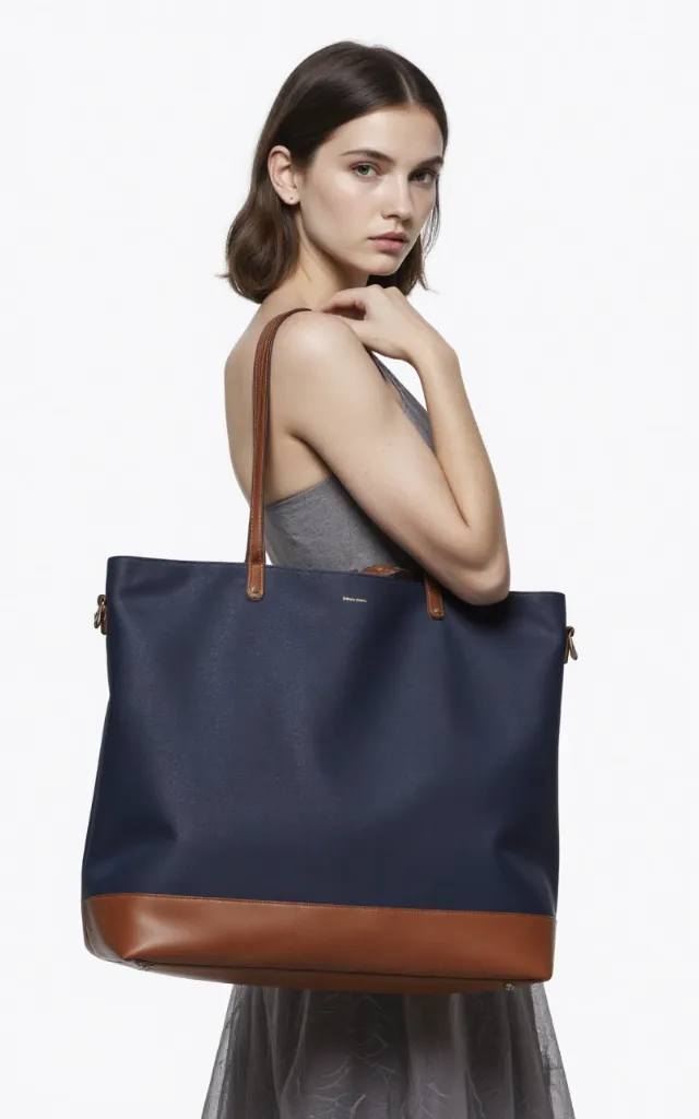 A French female model with a Work bag, wearing a dress, against a white background, in a front   facing close   up